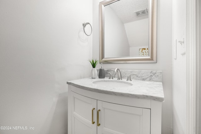 bathroom featuring vanity, visible vents, and a textured ceiling