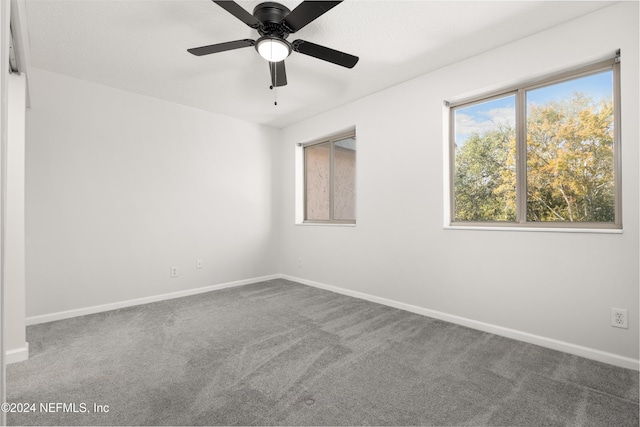 unfurnished room with a ceiling fan, baseboards, and carpet floors