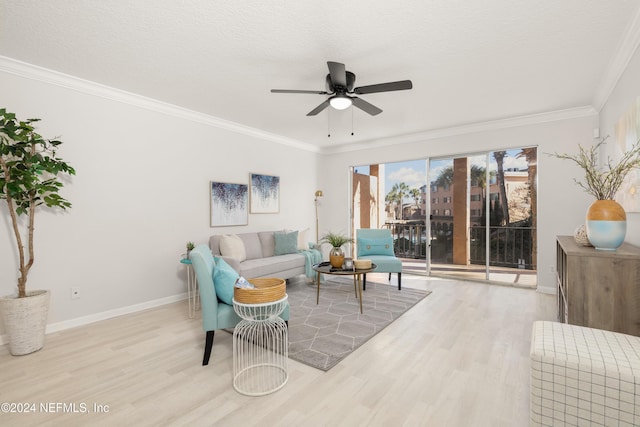 living area with wood finished floors, baseboards, ceiling fan, ornamental molding, and a textured ceiling