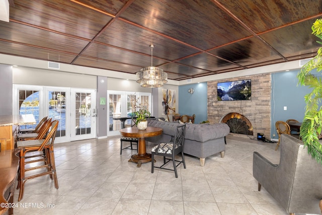 living room featuring wooden ceiling, light tile patterned floors, a fireplace, and visible vents