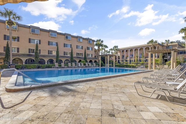 community pool with a patio and a pergola