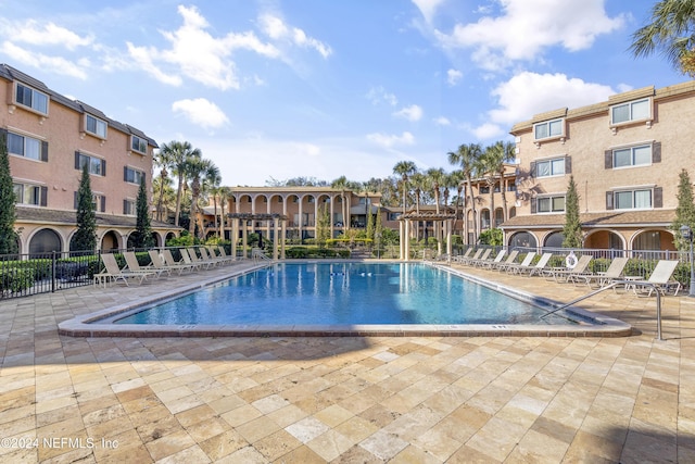 community pool with a patio and fence