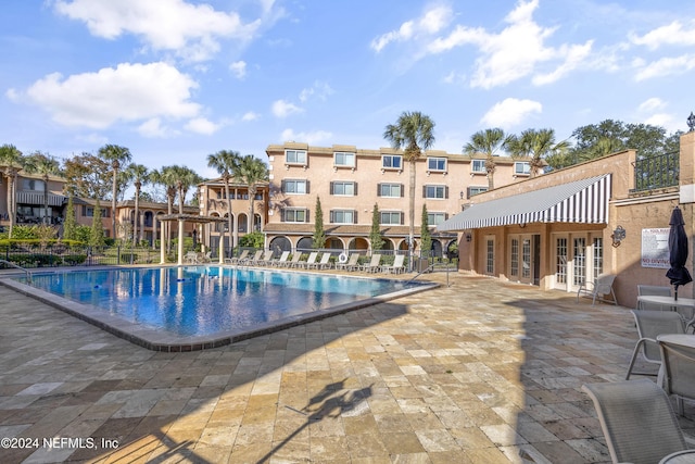 pool featuring a patio area, french doors, and fence