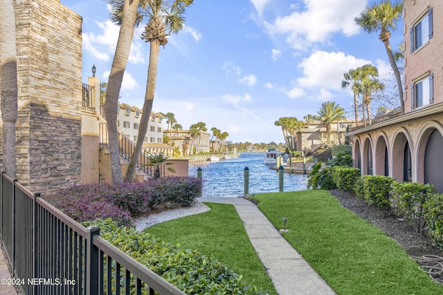 view of yard with a residential view, a water view, and a dock