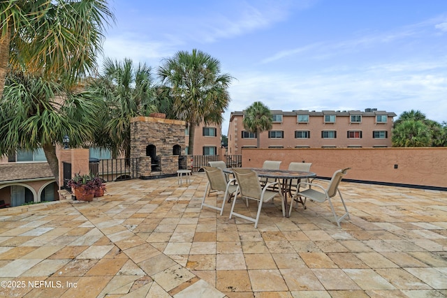 view of patio featuring outdoor dining area and an outdoor stone fireplace