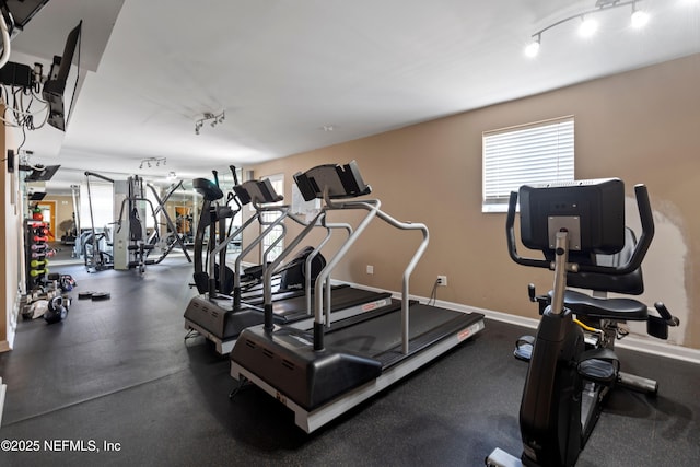 workout area with track lighting, plenty of natural light, and baseboards