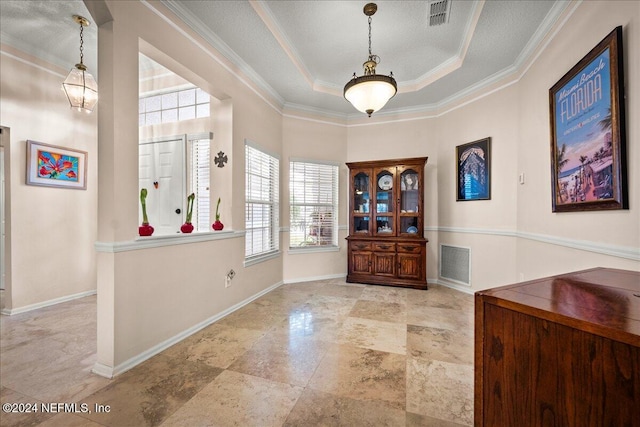 foyer entrance with baseboards, visible vents, a tray ceiling, and ornamental molding