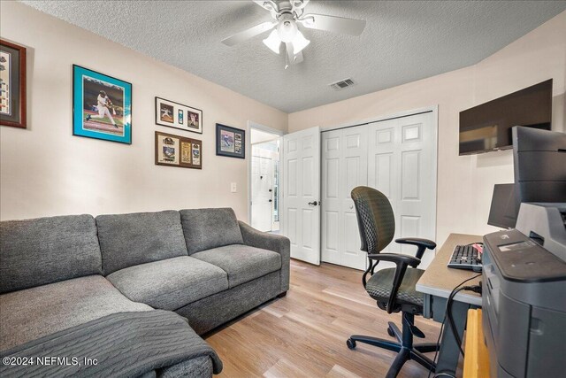 office featuring ceiling fan, a textured ceiling, visible vents, and wood finished floors