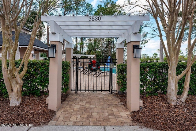 view of gate with fence and a pergola