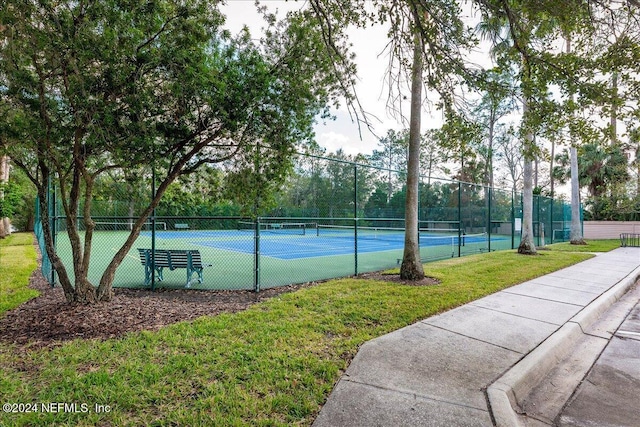 view of sport court featuring fence and a lawn