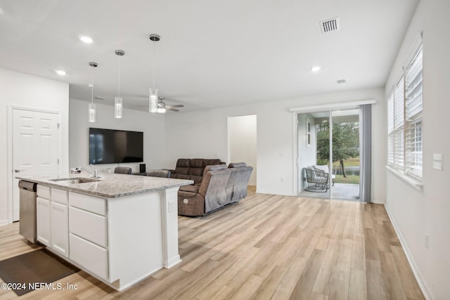 kitchen featuring stainless steel dishwasher, ceiling fan, an island with sink, light hardwood / wood-style floors, and white cabinetry