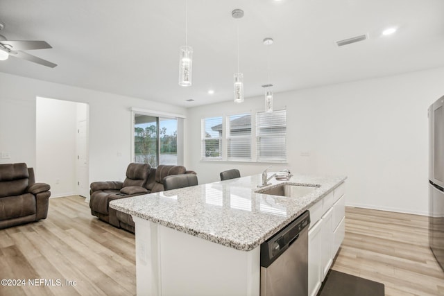 kitchen with sink, stainless steel dishwasher, decorative light fixtures, light hardwood / wood-style floors, and white cabinetry