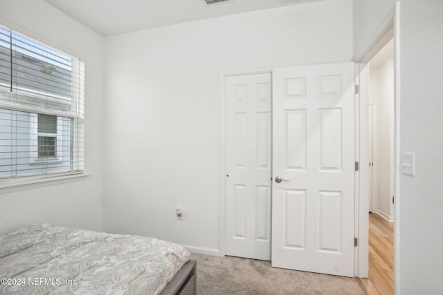 bedroom with light hardwood / wood-style flooring and a closet