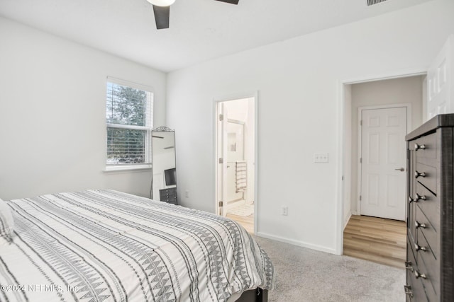 bedroom with ensuite bath, ceiling fan, and light colored carpet