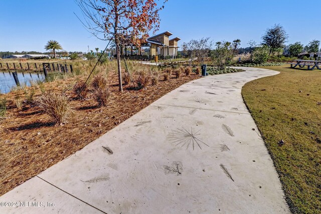 view of community with a water view and a yard