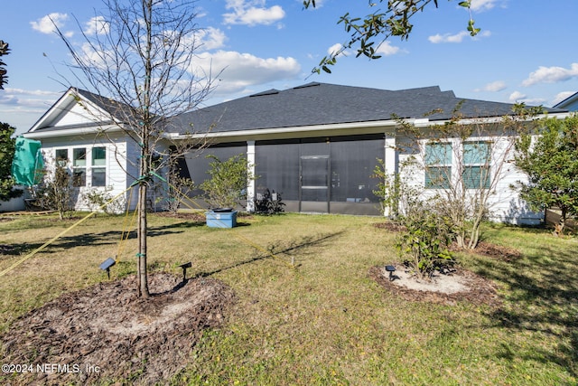 back of property featuring a yard and a sunroom