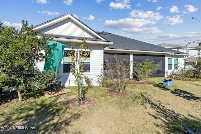 back of house with a sunroom and a lawn