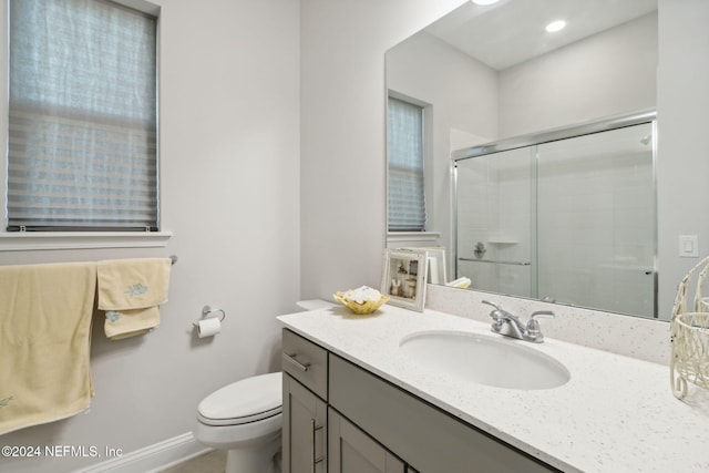 bathroom with vanity, toilet, and an enclosed shower