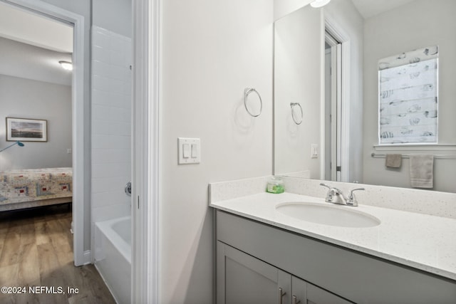 bathroom featuring washtub / shower combination, wood-type flooring, and vanity