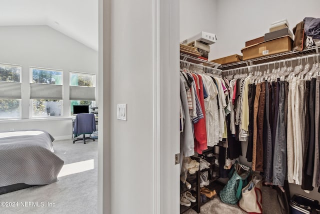 walk in closet with carpet floors and lofted ceiling