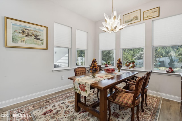 dining area with wood-type flooring and a chandelier