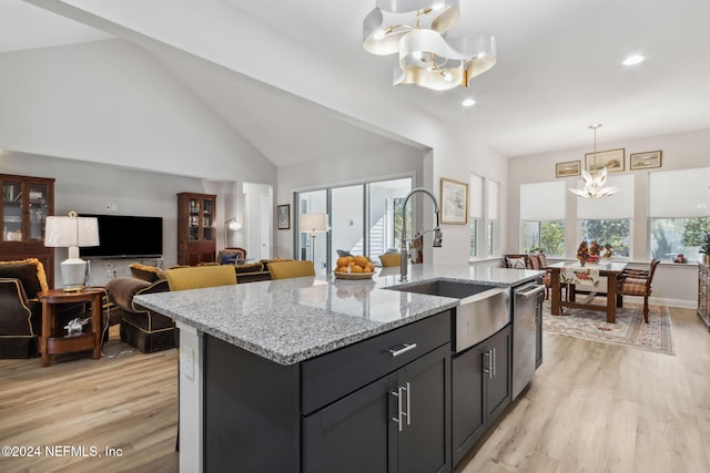 kitchen featuring plenty of natural light, an island with sink, and a chandelier