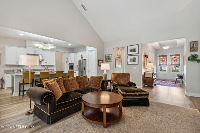 living room featuring light hardwood / wood-style floors and high vaulted ceiling