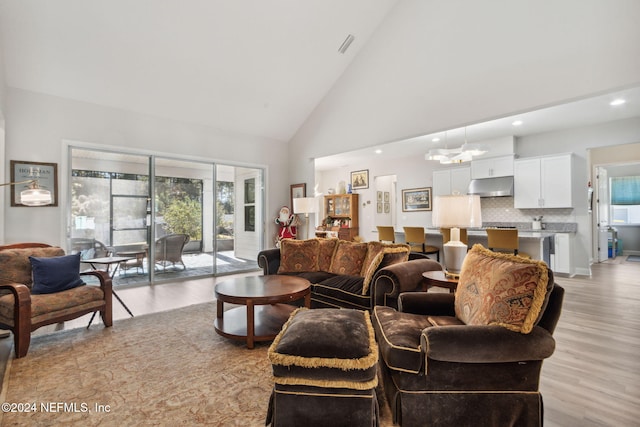 living room featuring light wood-type flooring and high vaulted ceiling