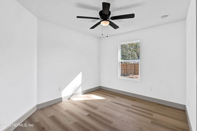 unfurnished room with a ceiling fan, a textured ceiling, baseboards, and wood finished floors