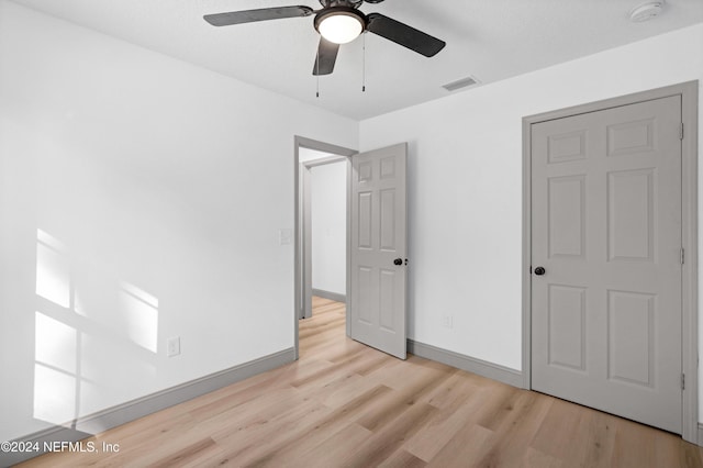 unfurnished bedroom with light wood finished floors, baseboards, visible vents, and a ceiling fan