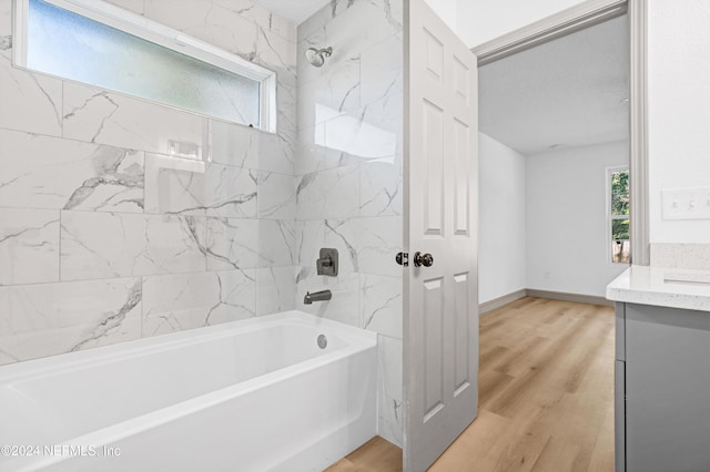 full bathroom with  shower combination, wood finished floors, vanity, and baseboards