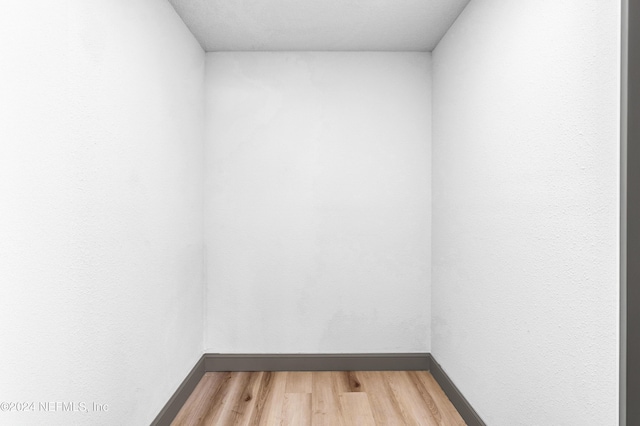 empty room featuring light wood finished floors and baseboards