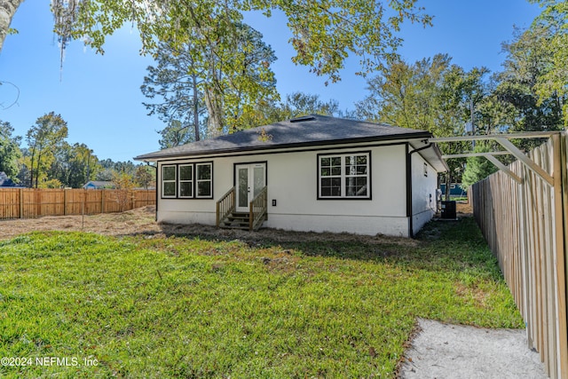 bungalow-style house featuring entry steps, a fenced backyard, a front lawn, and a shingled roof