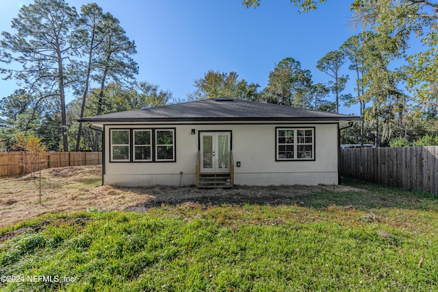 view of front of property with french doors, a fenced backyard, and a front lawn