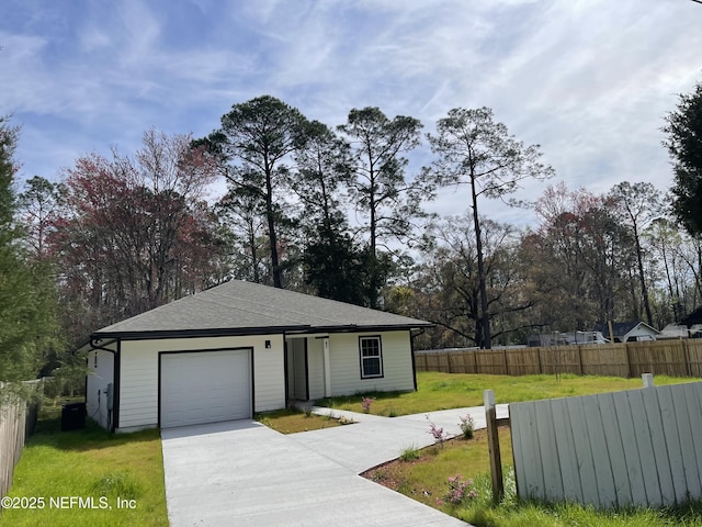 view of front of property featuring roof with shingles, concrete driveway, an attached garage, a front yard, and fence