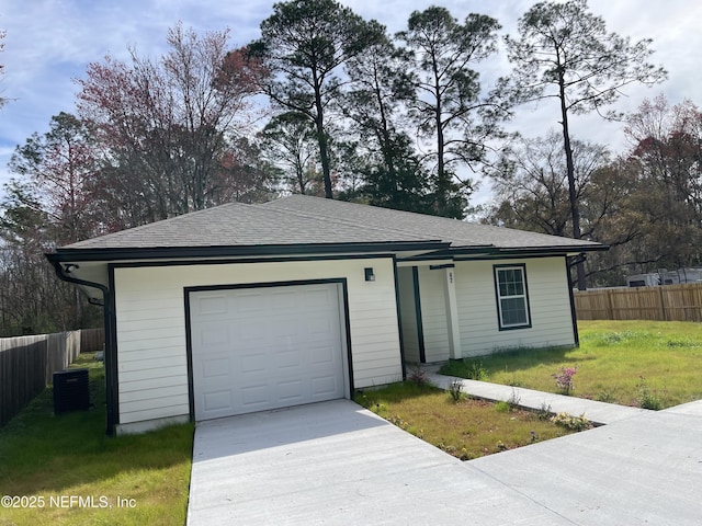 ranch-style house featuring an attached garage, driveway, a front yard, and fence