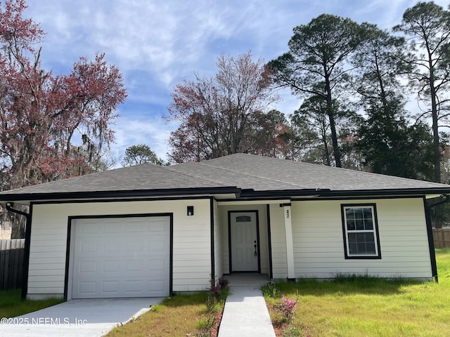 single story home with a garage, a shingled roof, fence, and a front yard