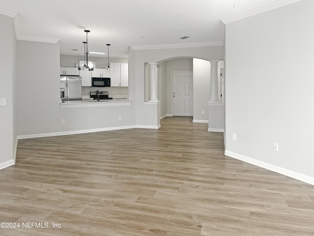 unfurnished living room featuring light hardwood / wood-style floors, an inviting chandelier, and crown molding