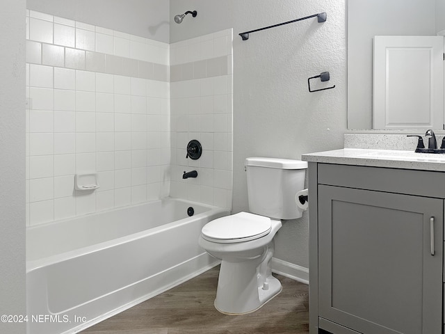 full bathroom featuring vanity, toilet, wood-type flooring, and tiled shower / bath