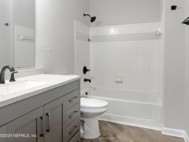 full bathroom featuring vanity, wood-type flooring, tiled shower / bath combo, and toilet