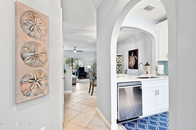 bar with white cabinetry, sink, stainless steel dishwasher, and light tile patterned floors