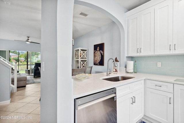 kitchen featuring sink, light tile patterned floors, tasteful backsplash, white cabinets, and stainless steel dishwasher