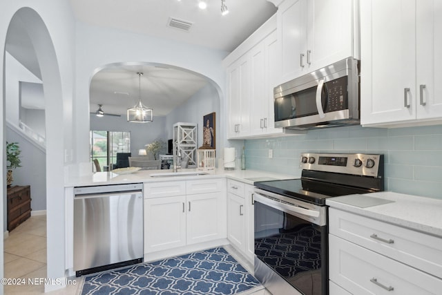 kitchen with sink, white cabinetry, light tile patterned floors, appliances with stainless steel finishes, and backsplash