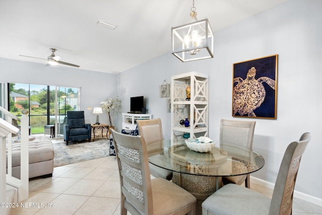 tiled dining area with ceiling fan with notable chandelier