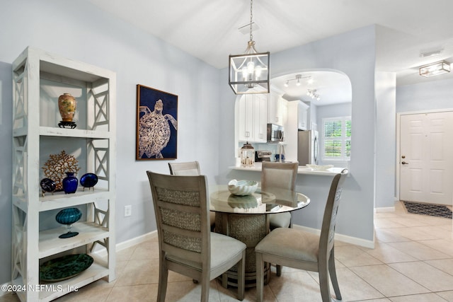 tiled dining space featuring a chandelier