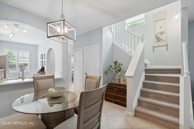 dining room featuring sink, a chandelier, and light tile patterned flooring