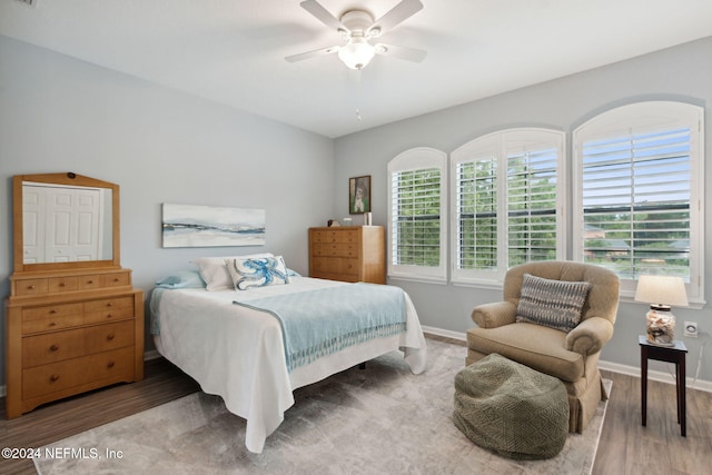 bedroom featuring dark wood-type flooring, ceiling fan, and multiple windows