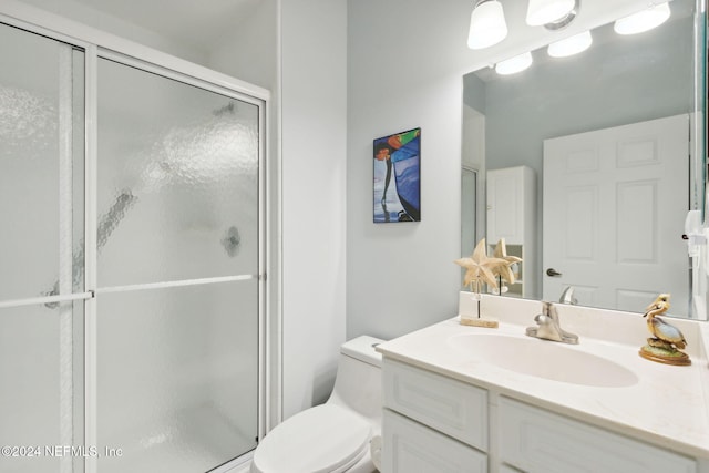 bathroom with an enclosed shower, vanity, and toilet