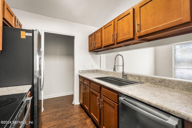 kitchen featuring appliances with stainless steel finishes, a textured ceiling, dark hardwood / wood-style floors, and sink