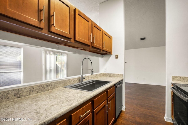 kitchen featuring a textured ceiling, dark hardwood / wood-style flooring, sink, and appliances with stainless steel finishes